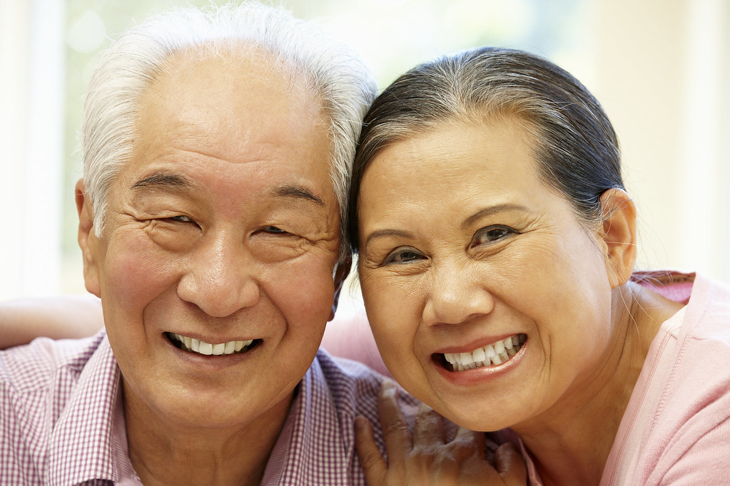 Pareja de adultos mayores sonriendo en casa